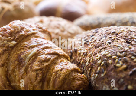 Close-up of Mixed Bread and baked Bread rolls usable as decorative Food Background. Freshly baked Whole-grain Bread Rolls with Sesame Seeds. Stock Photo