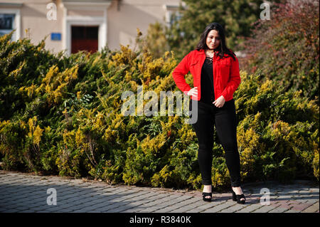 Pretty latino model girl from Ecuador wear on black and red jacket posed at street. Stock Photo