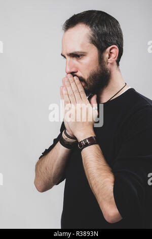 Bearded worried man on grey background. Stock Photo