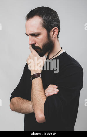 Bearded worried man on grey background. Stock Photo