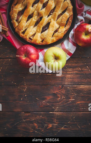 Homemade pastry apple pie with bakery products on dark wooden kitchen table Stock Photo