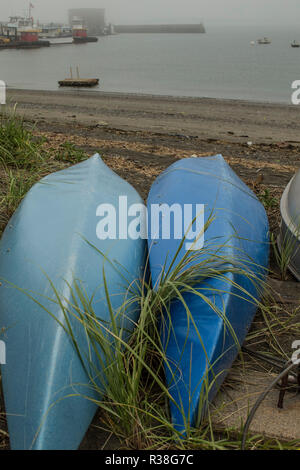Two Blue Kayaks on shoreline. Water, buildings, in background, Hull, MA. is a small fishing village on the South Shore, just south of Boston, MA. Stock Photo