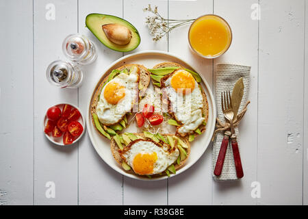 Delicious healthy breakfast with sliced avocado sandwiches with fried egg Stock Photo