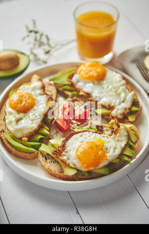Delicious healthy breakfast with sliced avocado sandwiches with fried egg Stock Photo