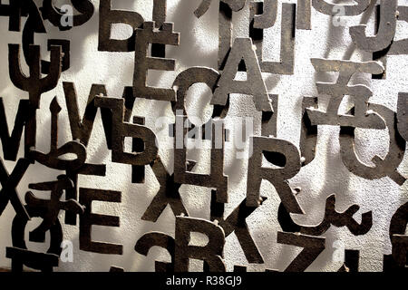 Metal letters attached to a wall form an artistic pattern Stock Photo