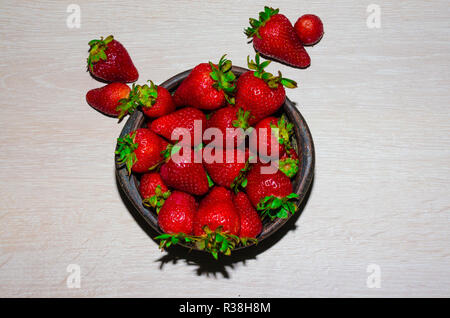fresas rojas maduras y frescas sobre vasija de greda Stock Photo