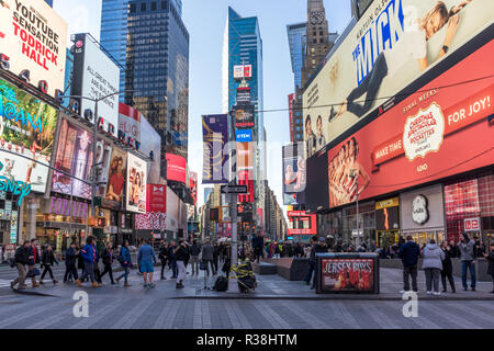 New York City, USA - December 25 2016: View TIme Square with no cars, a crowd of people walking by on the sidewalk, and multiple advertising signs in  Stock Photo