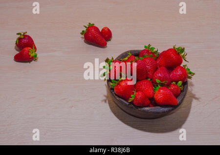fresas rojas maduras y frescas sobre vasija de greda Stock Photo