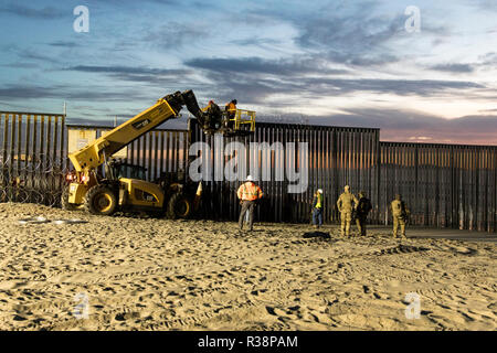 U.S. Customs and Border Patrol agents install concertina wire in preparation for the migrant caravan at Field State Park November 15, 2018 in Imperial Beach, California. Stock Photo