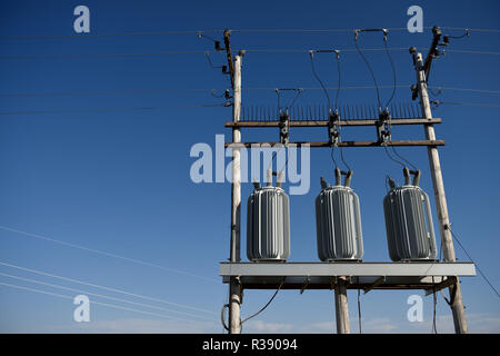 Electrical grid infrastructure, transformers, overhead high voltage power lines, against a blue sky in Wyoming / USA. Stock Photo