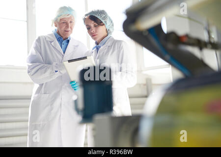 Workers Operating Machine at Factory Stock Photo