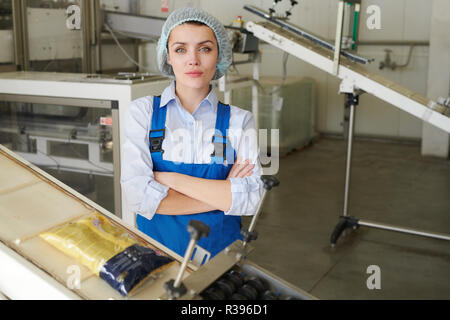 Female Worker Posing by Packaging Line Stock Photo