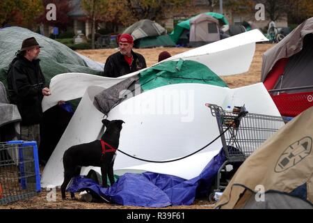 Butte, USA. 21st Nov, 2018. Residents talk near a tent at a parking lot in Chico of Butte County, California, the United States, Nov. 21, 2018. Local officials warned that the rain after the wildfire could cause risk of flash floods and mudflows. Credit: Wu Xiaoling/Xinhua/Alamy Live News Stock Photo