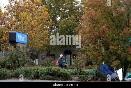 Butte, USA. 21st Nov, 2018. A resident walks to a tent at a parking lot in Chico of Butte County, California, the United States, Nov. 21, 2018. Local officials warned that the rain after the wildfire could cause risk of flash floods and mudflows. Credit: Wu Xiaoling/Xinhua/Alamy Live News Stock Photo