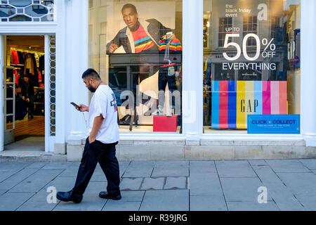 Bath, UK. 22nd November, 2018. With Black Friday sales due to start on Friday, a man is pictured as he walks past a store in the centre of Bath,UK. Credit: Lynchpics/Alamy Live News Stock Photo