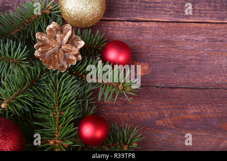 Christmas or New Year background: fur-tree, branches, colored glass balls , decoration and cones on a wooden background Stock Photo
