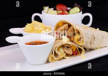 Delicious chicken wrap with salad inside with isolated black background Stock Photo