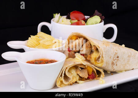 Delicious chicken wrap with salad inside with isolated black background Stock Photo