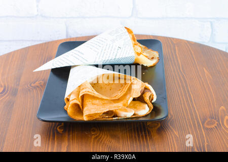Delicious banana crepe with chocolate dressing on wood table Stock Photo