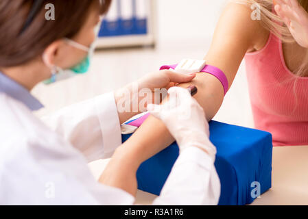 Young beautiful woman during blood test sampling procedure Stock Photo