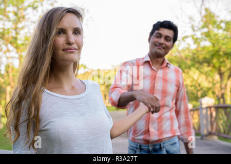 Close up of happy multi ethnic couple smiling with beautiful wom Stock Photo