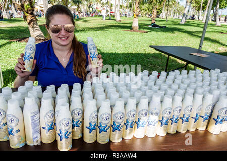 Miami Beach Florida,Ocean Drive,Veterans Day Parade activities,free suntan sunscreen lotion,Hispanic woman female women,offering,FL181115056 Stock Photo