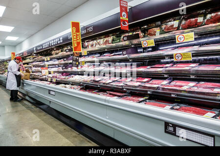 Miami Florida,Winn-Dixie,grocery store supermarket food,inside interior,beef meat department,butcher stock clerk stocking,employee working,display sal