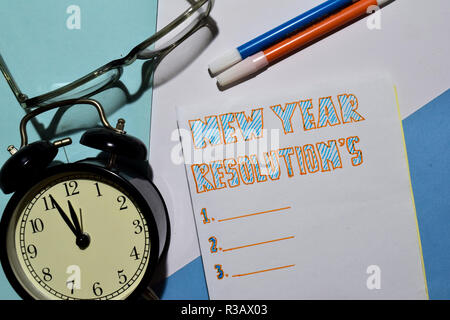 Top view New Year Resolutions text list with alarm clock, marker and eyeglasses for business presentation mock up for adding your list Stock Photo