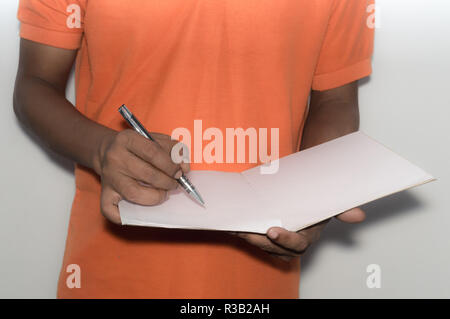 Selective focus on hand writing with pen, notebook. African American Asian business man standing and working with documents in office, analyzing proje Stock Photo