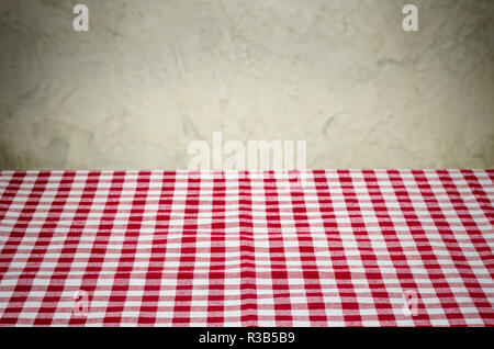 red and white plaid tablecloth in front of rustic wall Stock Photo