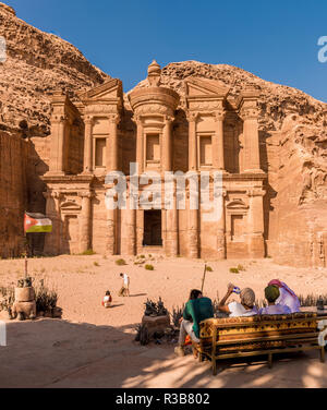 Tourists sitting on a bench, monastery, rock temple Ad Deir, rock tomb, Nabataean architecture, Khazne Faraun, mausoleum in the Stock Photo