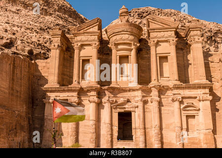 Jordanian flag, monastery, rock temple Ad Deir, rock tomb, Nabataean architecture, Khazne Faraun, mausoleum in the Nabataean Stock Photo