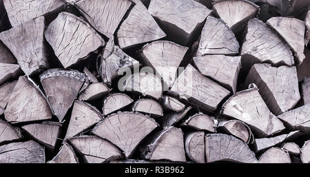 Wood pile texture. Chopped wood closeup in cold tones. Cut firewood for winter. Toned background of wooden logs. Stock Photo