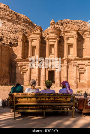 Tourists sitting on a bench, monastery, rock temple Ad Deir, rock tomb, Nabataean architecture, Khazne Faraun, mausoleum in the Stock Photo