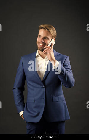 Business communication and modern life. digital marketing and new technology. Manager with beard on happy face speak on phone. Man in formal outfit with mobile phone. Businessman or ceo fashion. Stock Photo