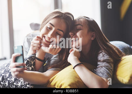 two sisters twins girl posing, making photo selfie, dressed same Stock  Photo | Adobe Stock