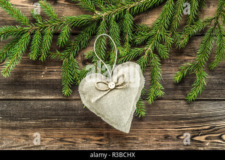 Textile decorative pillows in shape heart hanging on christmas tree branch Stock Photo