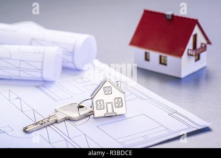 Blueprints and house as a keychain with architectural model | usage worldwide Stock Photo