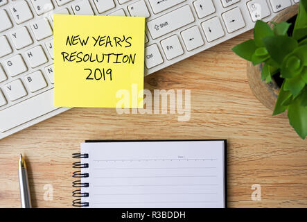 New Year Resolutions 2019 written on sticky note on Top Of Office desk Stock Photo