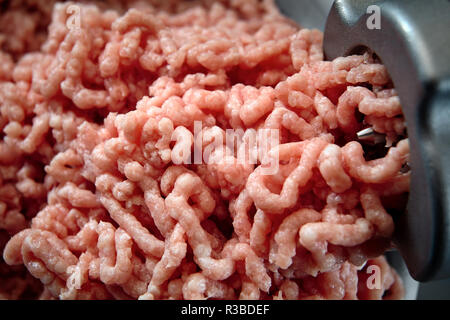 Minced meat coming out from grinder close-up. Healthy fresh homemade minced meat texture. Place for copyspace. Stock Photo