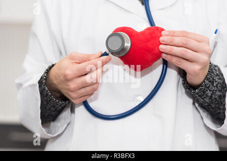 Cardiologist doctor. checking heart with stethoscope Stock Photo