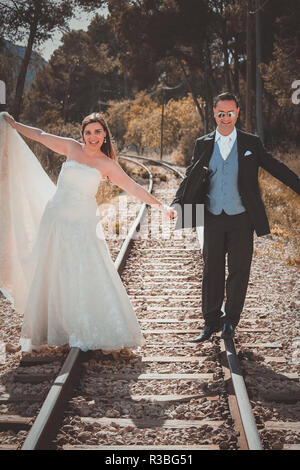 Just married couple walking on a railroad Stock Photo