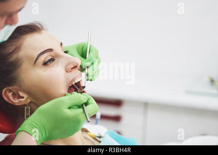 Dentist curing a female patient in the stomatology. Early prevention and oral hygiene concept Stock Photo