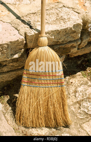 An old straw broom ready for cleaning Stock Photo