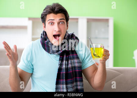 Young handsome man suffering from illness at home Stock Photo