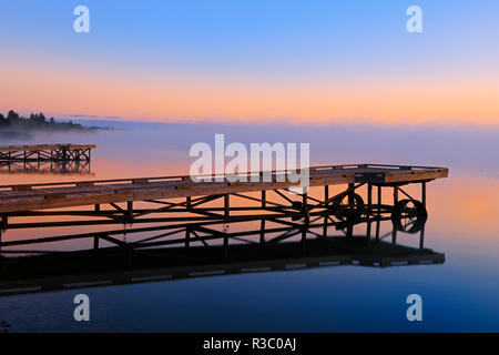 Canada, Alberta, Williamson Provincial Park. Docks in sunrise fog on Sturgeon Lake. Stock Photo