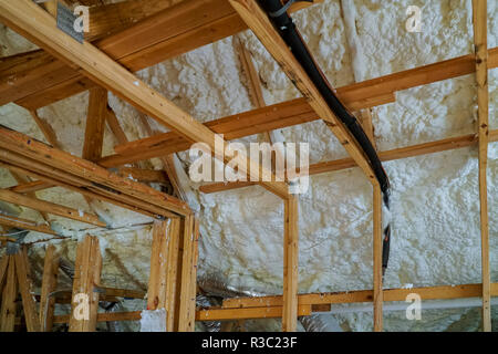 Installing thermal foam polyurea insulation under the roof wool panels and wooden planks Stock Photo