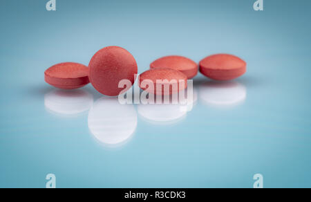 Selective focus on orange round tablets with shadow on gradient background. Pharmaceutical industry. Pharmacy products. Vitamins and supplements conce Stock Photo