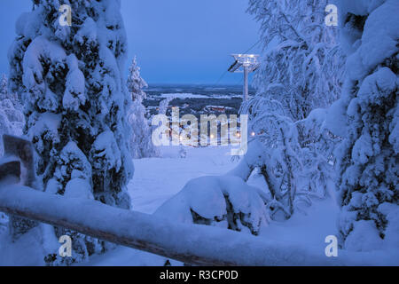 Winter wonderland evening landscape view on Levi ski resort in Laplandia, Finland, with ski lift, village and trees covered by snow. Seasonal winter g Stock Photo