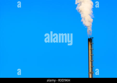 Power plant smokestack with carbon emission - co2, dioxide or fossil fuel. Air pollution by industry. Chimney and smoke cloud on blue sky background. Stock Photo